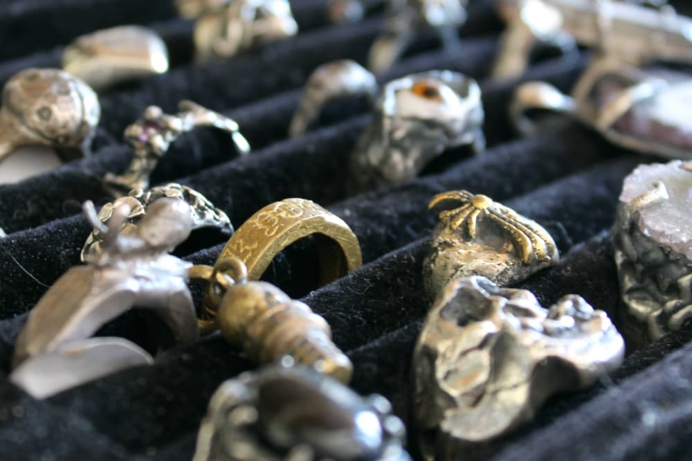 Chunky gold and silver rings in a display case. 