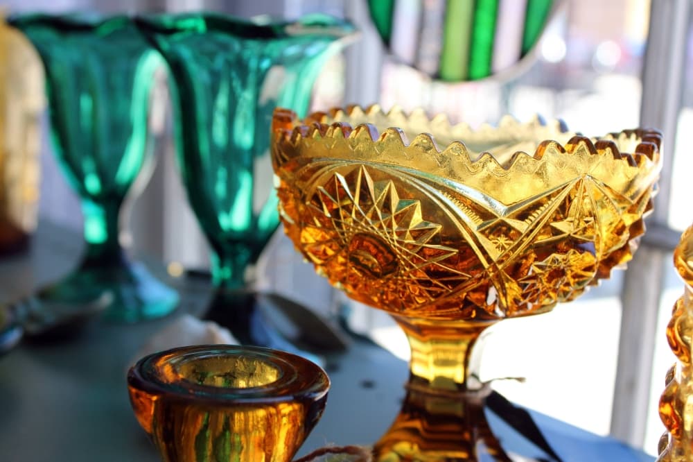 Colored glassware displayed in a window. 