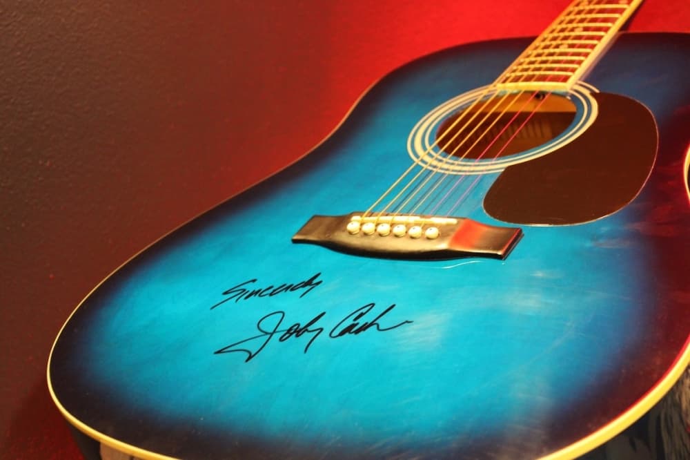 A blue guitar scrawled with a signature.