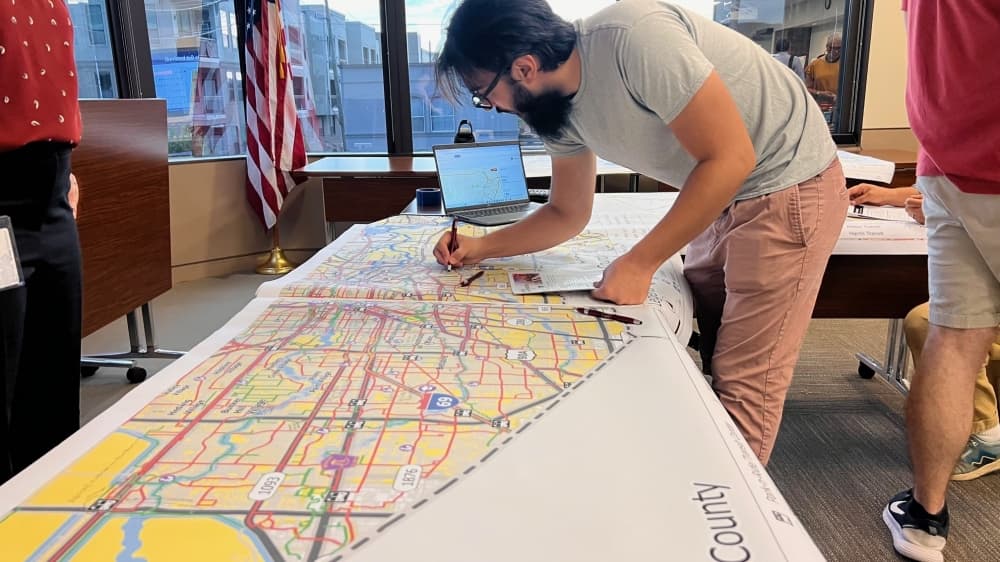 Resident signing a map on a table.