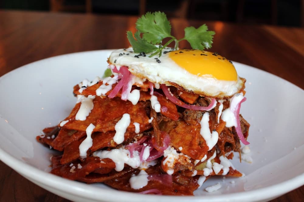 Stack of barbacoa topped with fried eggs.