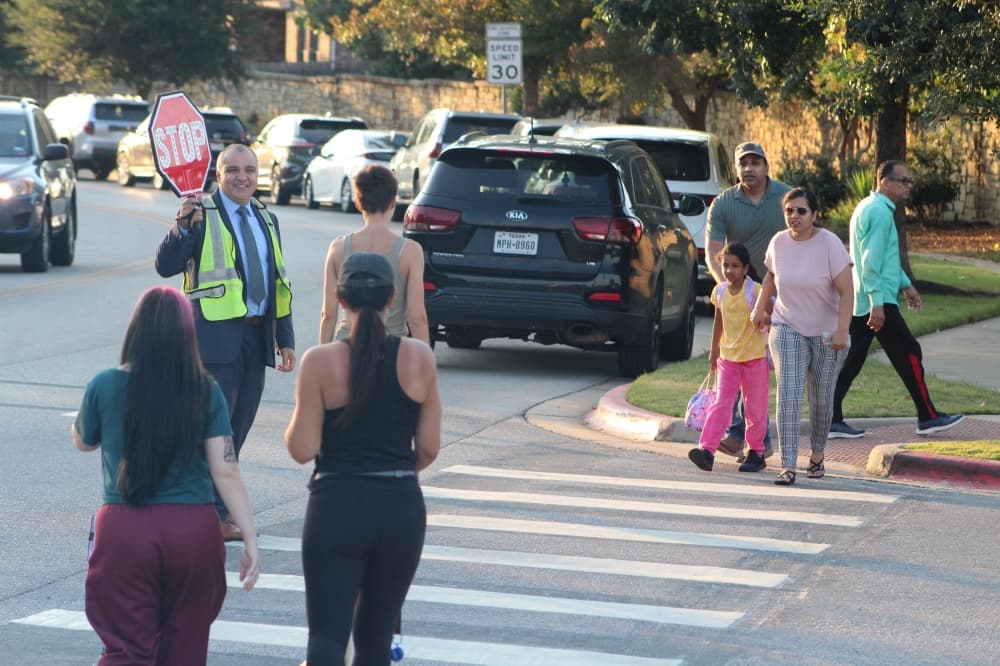 Superintendent Hafedh Azaiez stands in as a crossing guard for the first day of school. (Grant Crawford/Community Impact)