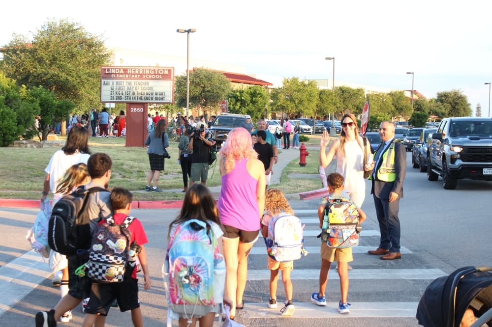 Students and their families walk to Linda Herrington Elementary School. (Grant Crawford/Community Impact)