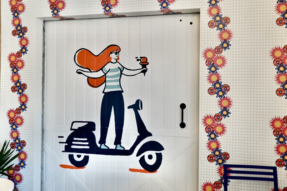Rossa Room is hidden behind a white sliding door that has a woman holding gelato painted on it. (Roo Moody/Community Impact)