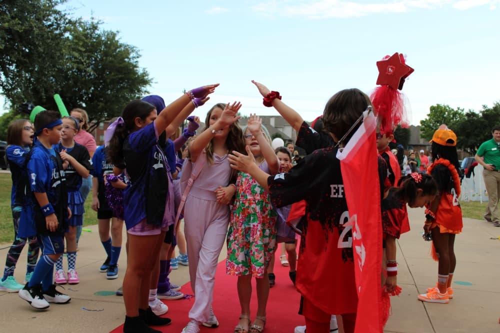 Eagle Ridge elementary students in their team uniforms welcome students back to school.