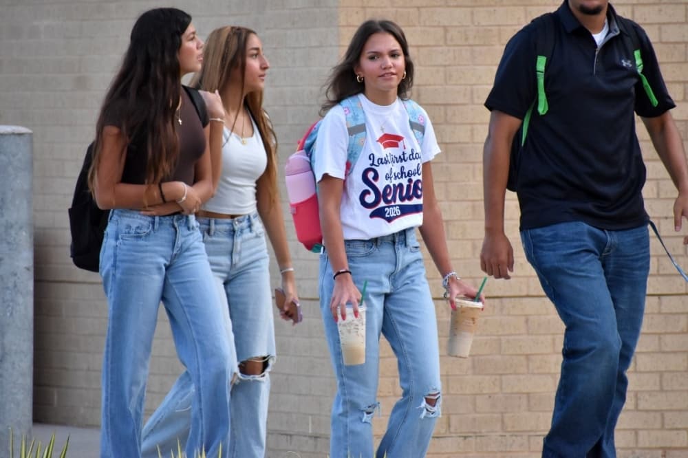 Student carrying 2 cups from Starbucks