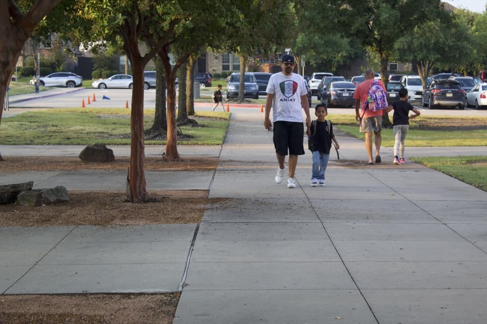 Parents walk their children inside Tadlock Elementary for the first day of school on Aug. 13. (Samantha Douty/Community Impact)