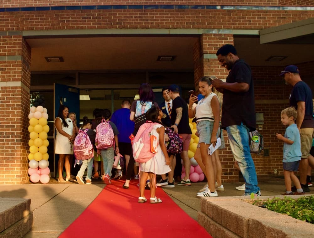 Students walking in the school with a parent taking a photo