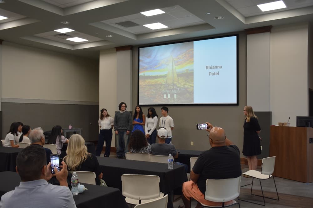 Five Flower Mound High School students speak about their murals painted inside library study rooms during an Aug. 12 event.