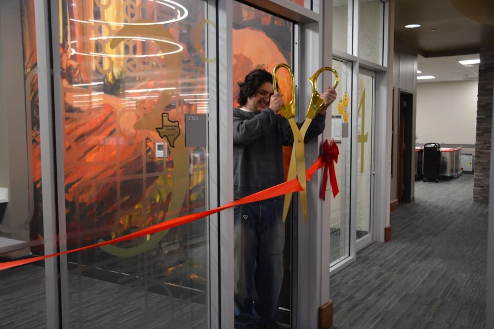 Gael Giovani Guardado cuts a ribbon at study room No. 3, which contains his Piney Woods mural.