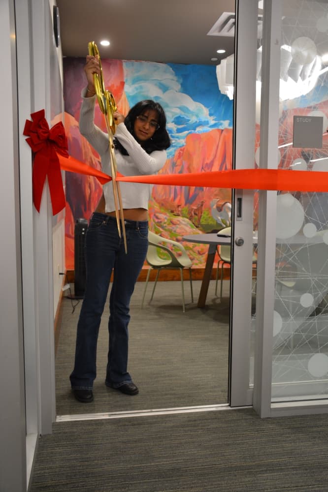 Soun Reddy cuts the ribbon outside the study room with her mural.