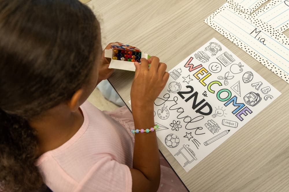 A student colors on a provided page with crayons.  (Courtesy Hutto ISD)