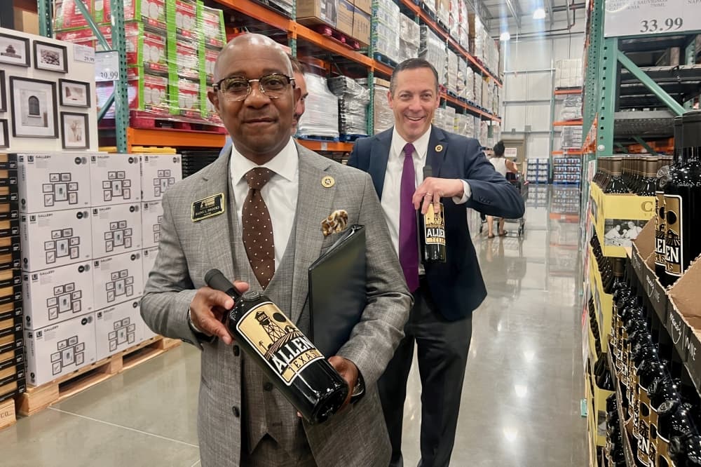 Allen Mayor Baine Brooks and City Council member Tommy Baril holding wine bottles