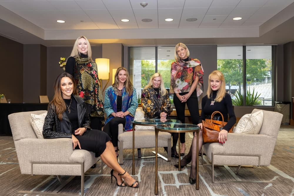 people gathered in a room modeling jewelry