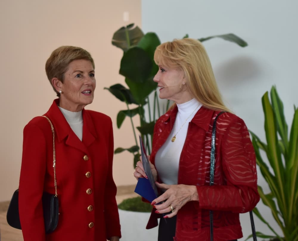 Two women in red talk