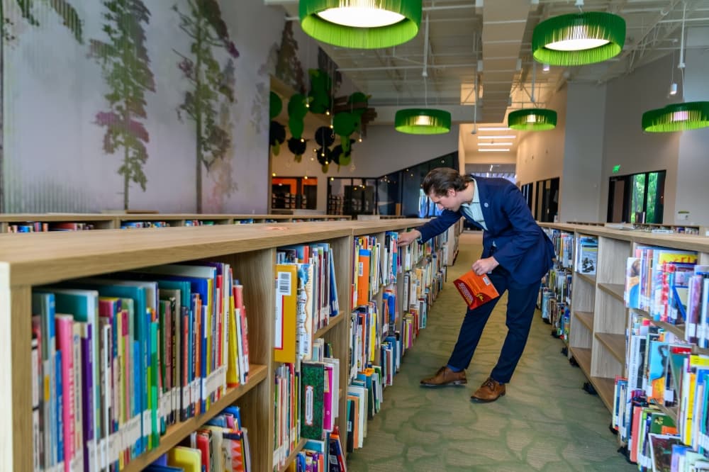 putting books on library shelf
