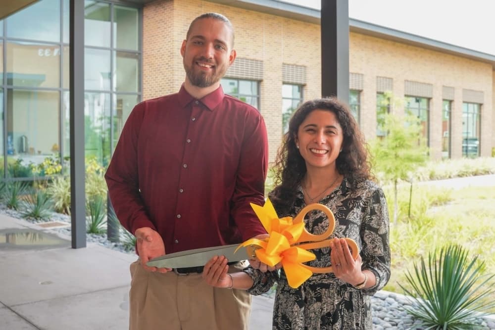 A photo of Harris County Judge Lina Hidalgo standing with a ribbon-cutting ceremony scissor.