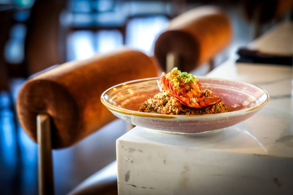 Seafood and pasta dish sitting on the edge of a white bar. 