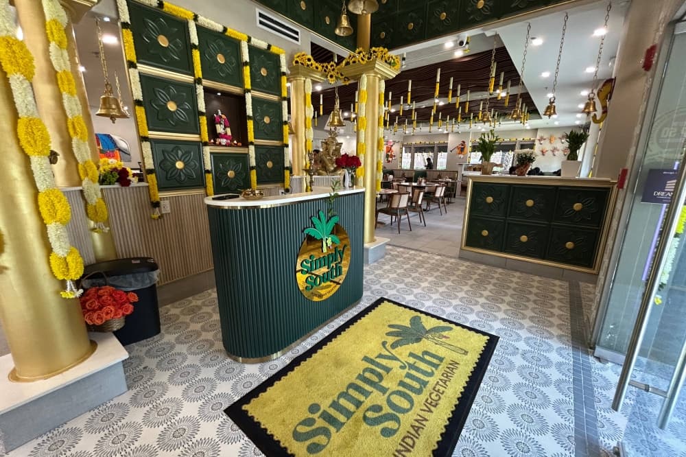 Interior of a restaurant entrance featuring yellow and green design elements. 