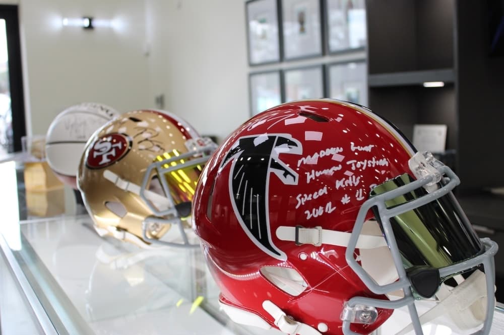Signed NFL helmet on a countertop from the Atlanta Falcons and San Francisco 49ers.