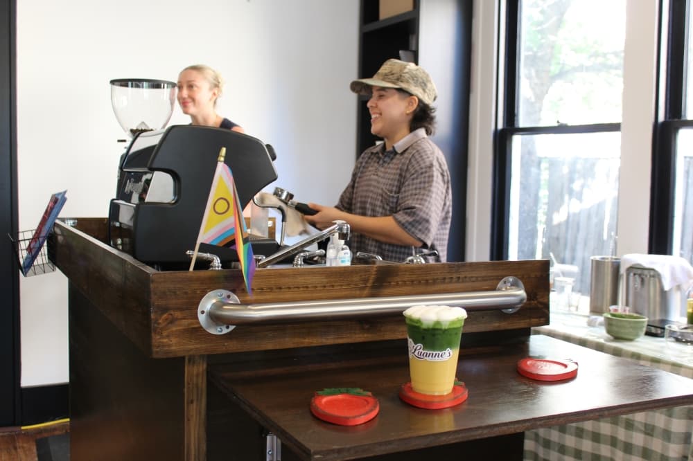 Two women make coffee at a mobile drink cart