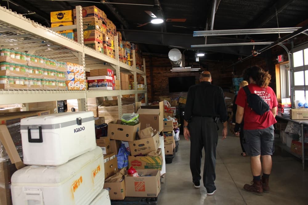 Pictured is a lot of food items and two people looking at them.