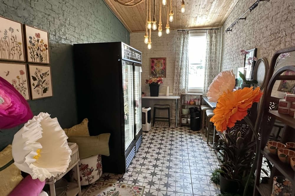 The portion of the building is shown that houses the flower shop, with a flower fridge and large silk flowers.