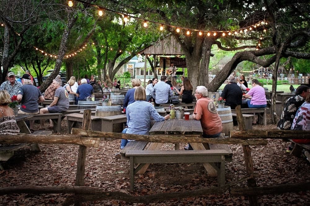 A garden with patrons enjoying company and drinking spirits.