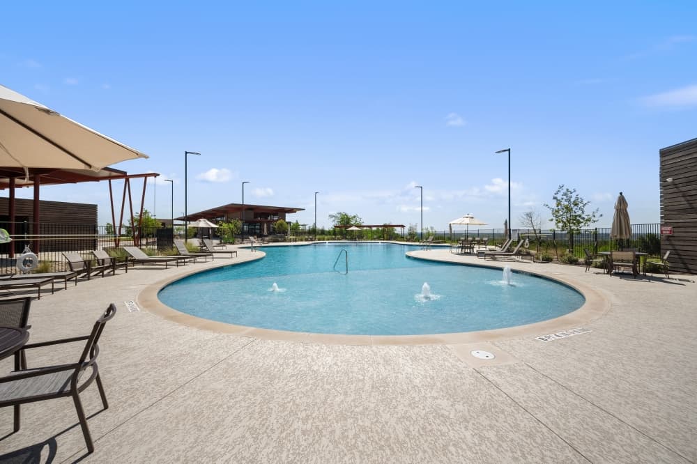 Resort-style community pool at Trails at Wildhorse in East Austin with lounging area, family-friendly amenities, and amenities for active lifestyles