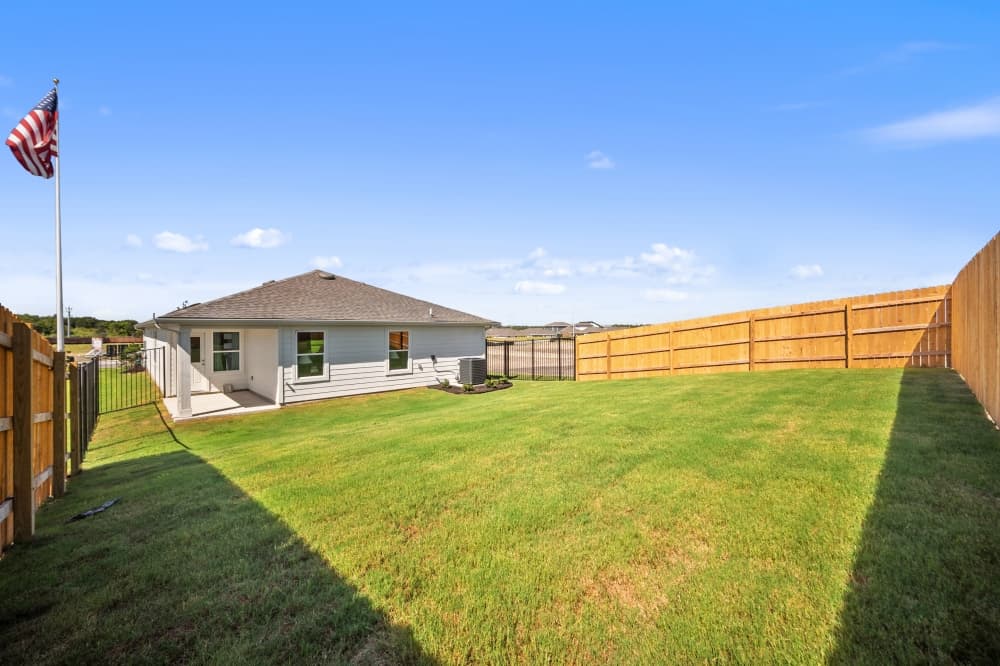 Private backyard of a Trails at Wildhorse home in East Austin featuring covered patio, outdoor space for entertaining, and modern Austin home design by D.R. Horton