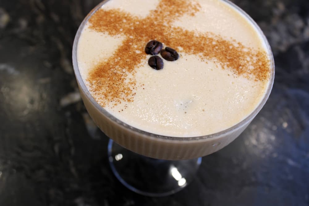 Frothy martini topped with three coffee beans and spices.