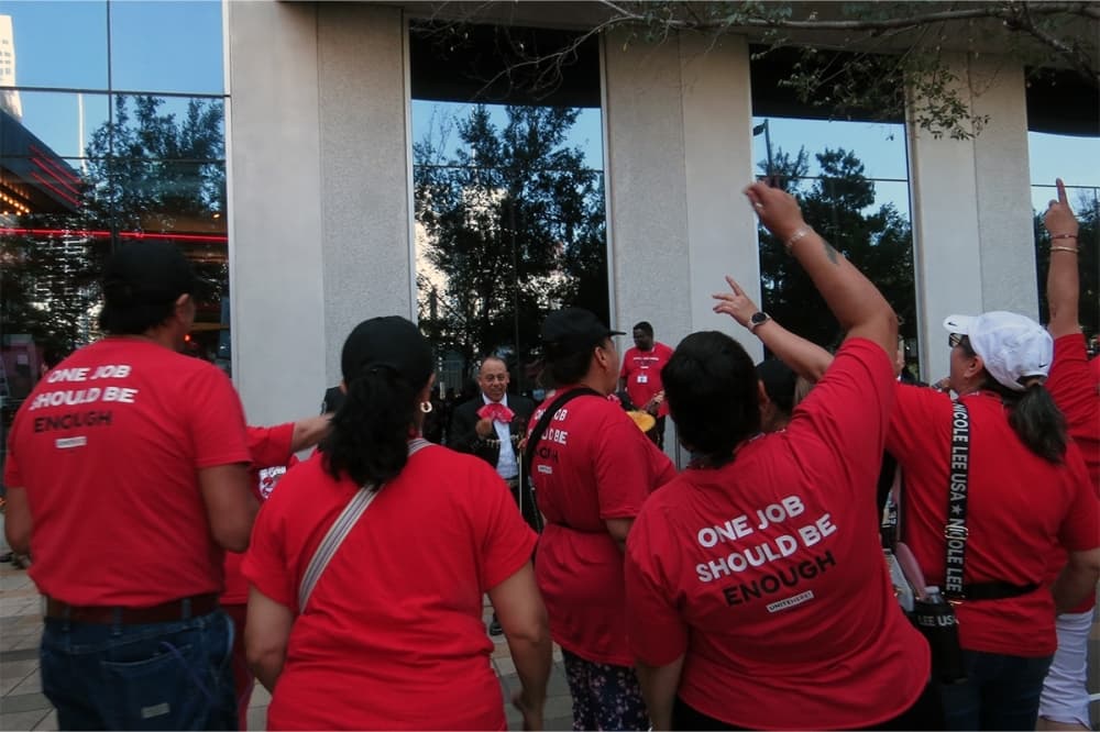 people on strike raised their arms outside of a building