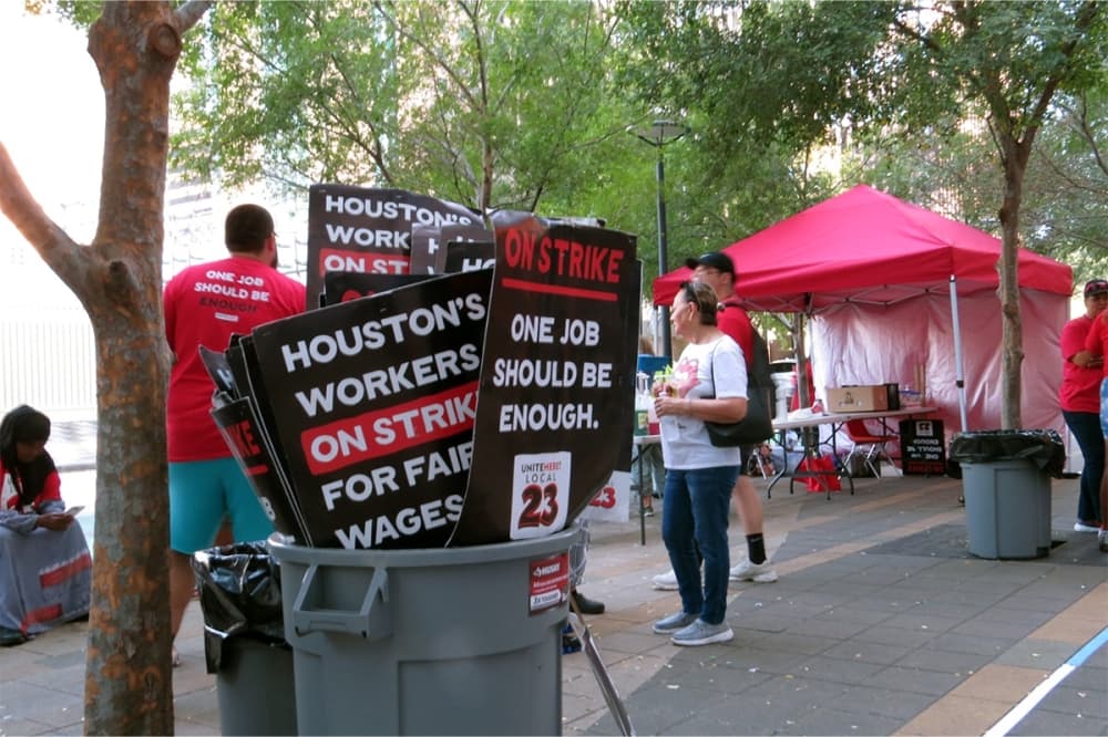 protest signs in a trash bin outside