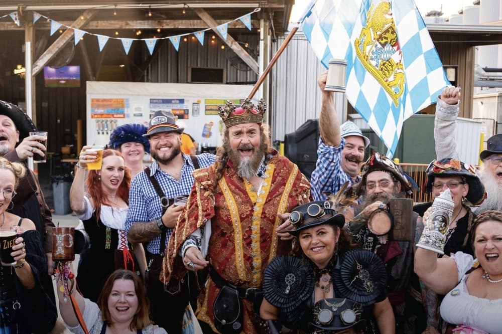 people in German attire raise drinks