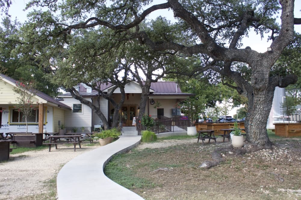 The back entrance features many rows of picnic tables, many of were designed by Leticia. The custom tables feature a small tree coming through the top of the table. (Sienna Wight/Community Impact) 