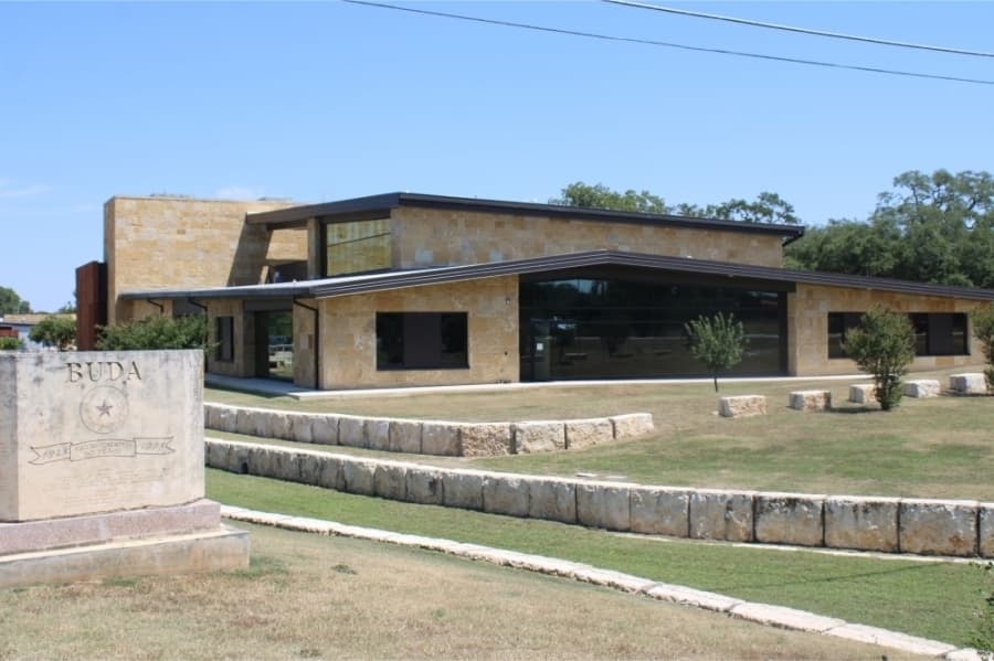 Pictured is Buda City Hall with a sign that says Buda.