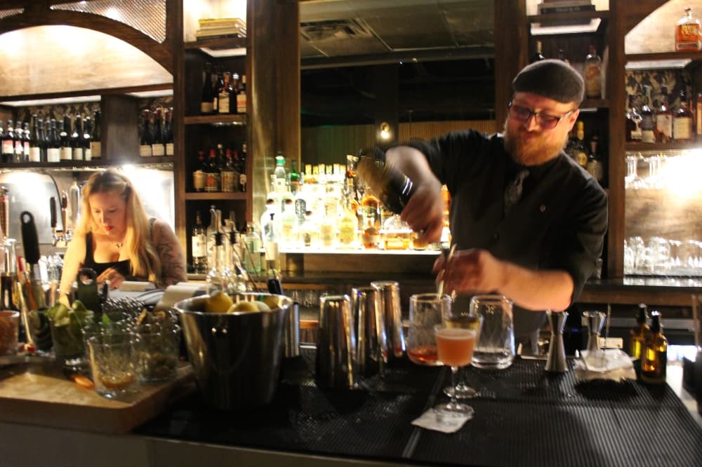 A bartender pours a drink