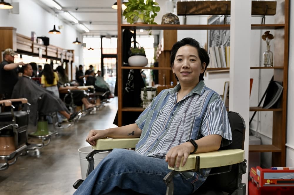a woman sits in a chair in a barbershop