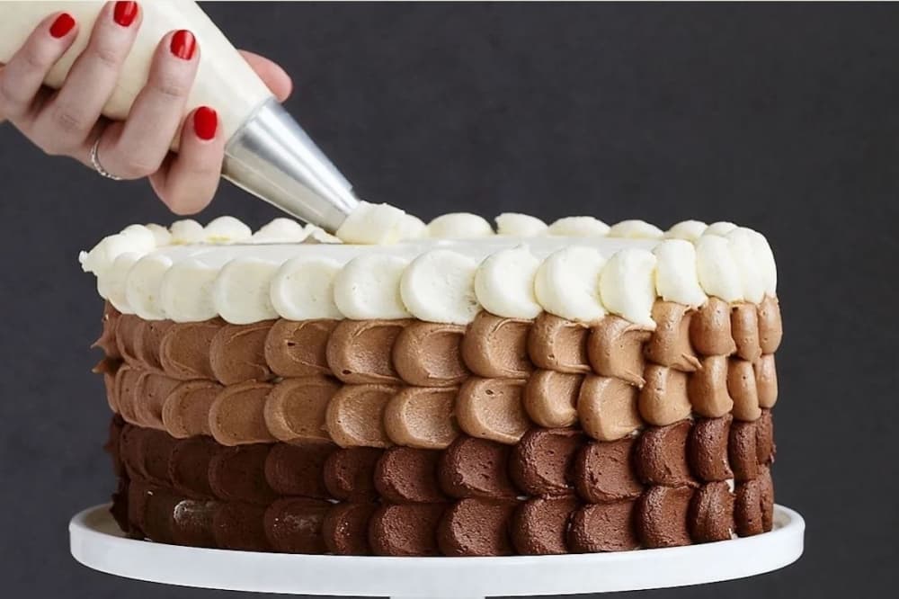 hand frosting a cake