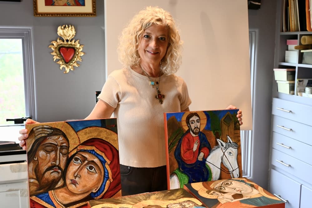 woman holds up artwork
