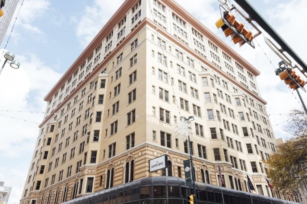 The exterior of a tall hotel in a city.
