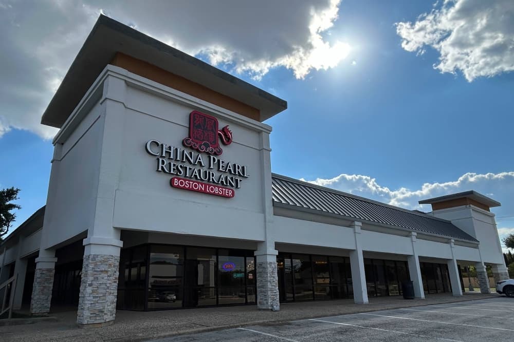 Exterior of a strip mall featuring Chine Pearl Restaurant signage. 