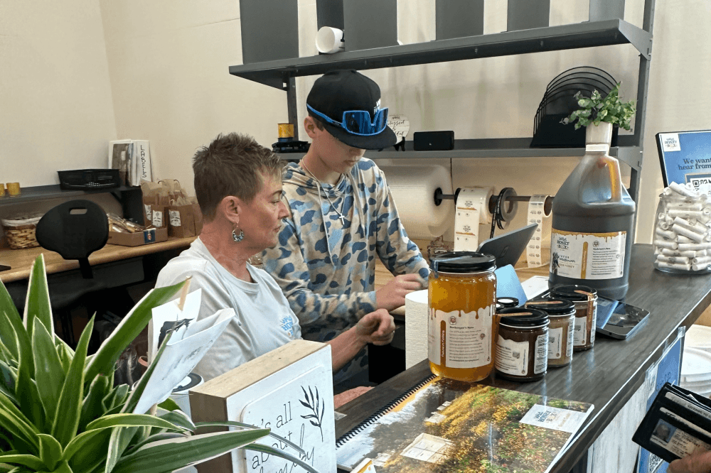 Wild Honey Box store display of local raw honey, spicy hot honey varieties, and handcrafted skincare made with beeswax.