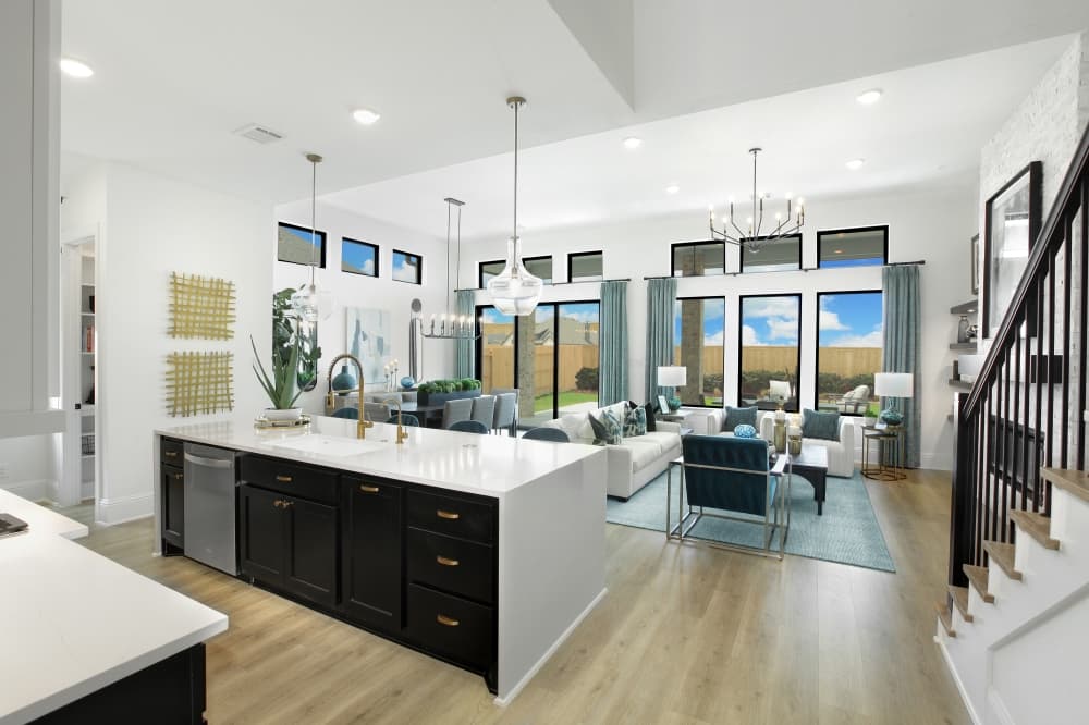 Interior of a Drees Custom Home at Grange showcasing an open-concept living space with tall ceilings, natural light, and a modern kitchen ideal for everyday family life.