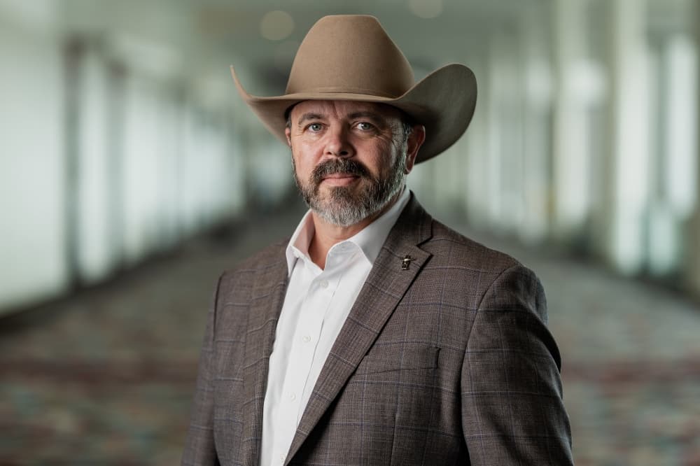 man in a brown suit wearing a cowboy hat