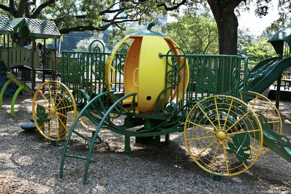 a green and yellow playground shaped like a pumpkin
