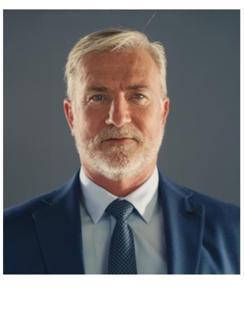 portait photo of a man with white hair and a beard wearing a blue suit and tie 