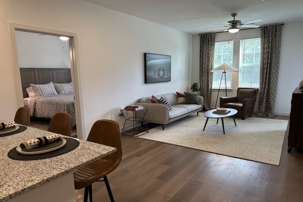 The interior of an affordable apartment complex unit is shown in Schertz, Texas with wood flooring and white walls.