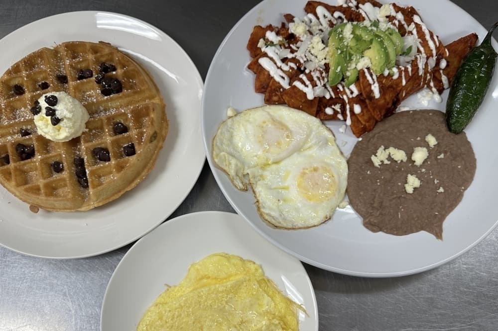 Overview of plated dishes including waffles, eggs, beans and more. 