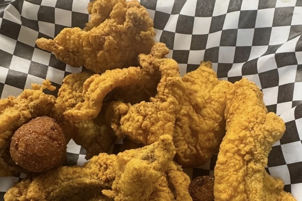 Fried food on a black and white checkered paper liner. 